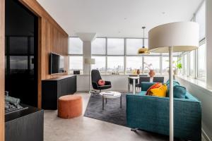 Una sala de estar con un sofá azul y una mesa. en BizStay Toren van Oud, en La Haya