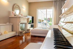 a living room with a piano and a fireplace at ComeCasa La Finestra sul Mare Apartment in Aci Castello