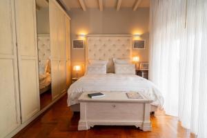 a bedroom with a bed and a table with a book on it at ComeCasa La Finestra sul Mare Apartment in Aci Castello +16 photos