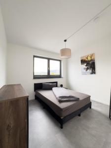 a bedroom with a bed and a picture on the wall at Apart das Ehrets mit 3 Schlafzimmer in Bretzfeld