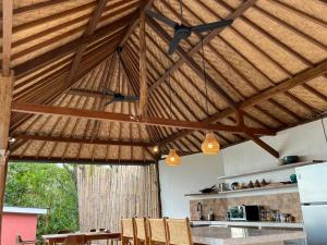 a kitchen with a large wooden ceiling with lights at Amed Hill Ocean View in Ambat