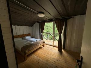 a bedroom with a bed in a room with a window at Відпочинковий комплекс Біла Кобила in Verkhovyna