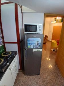 a kitchen with a microwave on top of a refrigerator at Qurum Heights Hotel in Muscat