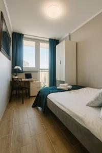 a bedroom with a bed and a desk with a laptop at V Ajax Warsaw Bed&Breakfast ROOMS in Warsaw
