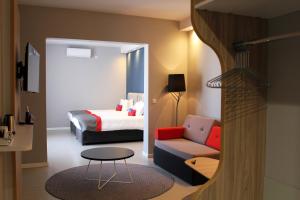 a hotel room with a bed and a couch and a table at Holiday Inn Express - Malta by IHG in St. Julianʼs