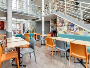 a cafeteria with tables and chairs and stairs at HotelF1 Bourges Le Subdray in Bourges