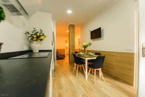 a kitchen and dining room with a table and chairs at Apartamento Reyes Católicos Conil in Conil de la Frontera