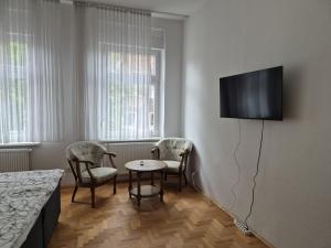 a room with two chairs and a table and a tv on the wall at Dania Apartments - zentral, ruhig in Castrop-Rauxel