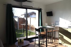 a kitchen with a table and chairs and a large window at Le Jardin de Sauge in Le Teich