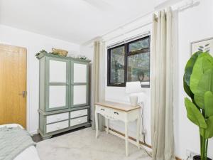 Schlafzimmer mit einem Schreibtisch und einem Fenster in der Unterkunft Lake View Lodge & Outdoor Bath in East Grinstead + 8 Fotos