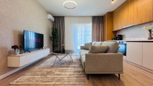 a living room with a couch and a tv at Crystal North Deluxe Apartments - Modern Comfort & Style in Voluntari