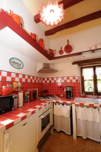 Saint-Germain-des-GroisにあるAu bord de l'Huisneの赤と白のタイル張りのカウンタートップを備えたキッチン +11枚の写真