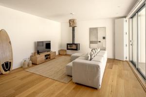 un soggiorno bianco con un divano e una TV di Ericeira Modern & Bright with Pool by Homing a Barril