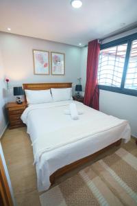 Un dormitorio con una cama grande y una ventana en Ocean Vibes Sea View and Fast Wi-Fi, en Tánger