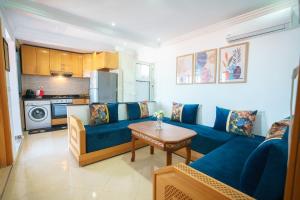 Una sala de estar con un sofá azul y una mesa. en Ocean Vibes Sea View and Fast Wi-Fi, en Tánger
