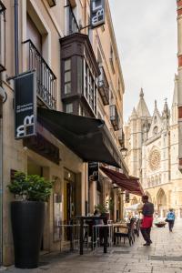 una persona caminando por una calle de la ciudad con un edificio en Hostal Albany, en León