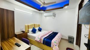 a bedroom with a bed and a desk and a room with a ceiling at The Imperial Residence Banani in Dhaka