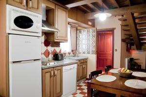 a kitchen with a table and a white microwave at Casa Rural Arbequina - Naturaleza y Calma en el Valle del Ambroz in Casas del Monte