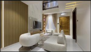 a living room with a couch and chairs and a television at The Emeritus Apartments in Akure