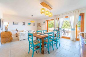 a kitchen and dining room with a table and chairs at Giardino sul Mare - Elegante Appto con Wi-Fi e AC in Marina di Portisco +30 photos