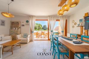 a kitchen and living room with a table and a couch at Giardino sul Mare - Elegante Appto con Wi-Fi e AC in Marina di Portisco