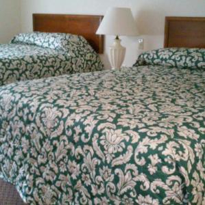 a hotel room with two beds and a lamp at Stay Lodge of Thomasville in Thomasville