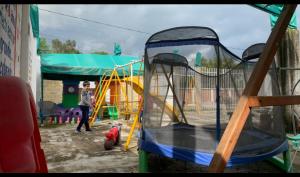 a person standing next to a playground with a slide at SUITES HOTEL natural Africam Safari in Santo Tomás Chautla
