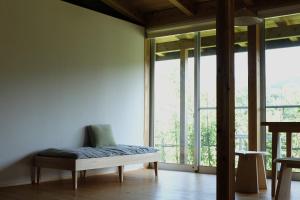 una habitación con un banco frente a una ventana en Lotus Retreat ロータスリトリート 高知空港から車で35分 山のふもとの一棟貸しコテージ, en Kami