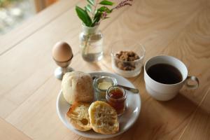 een bord brood en eieren en een kop koffie bij Lotus Retreat ロータスリトリート 高知空港から車で35分 山のふもとの一棟貸しコテージ in Kami +9 foto's