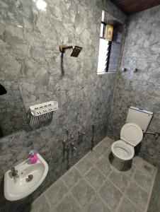 a bathroom with a toilet and a sink at 7 Hill Stays in Panchgani