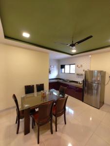 a dining room with a table and chairs and a refrigerator at 7 Hill Stays in Panchgani +27 photos