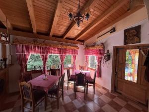 a dining room with tables and chairs and red curtains at Resort Zevs Komovi in Trešnjevik