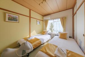 een slaapkamer met twee bedden en een raam bij TDR車9分 3BR 5Bed 夢の続きを楽しめる宿 -TAMU-LAND Kasai- in Tokyo