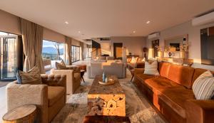 a living room with couches and a couch and a table at Intle Boutique Hotel in Jeffreys Bay