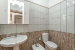 Un baño con lavabo, inodoro y espejo. en Casa Volcán y Mar 1 Derecha, en Playa de San Juan 16 fotos más