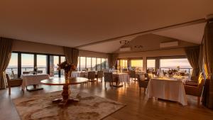 a dining room with tables and chairs and windows at Intle Boutique Hotel in Jeffreys Bay