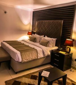 a bedroom with a large bed and a table at Dview Hotel in Lagos
