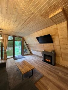a living room with a fireplace and a wooden ceiling at Cabana Vatra Râului 