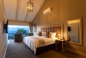 a bedroom with a large bed and a large window at Intle Boutique Hotel in Jeffreys Bay