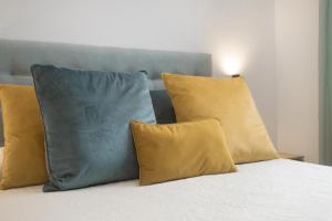 un letto con cuscini gialli e blu sopra di Casa Jazmin a Campano