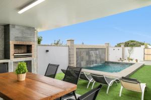 un patio con tavolo e sedie in legno e una piscina di Casa Jazmin a Campano Altre 13 foto