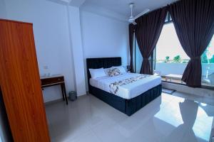 a bedroom with a bed and a large window at Harbour View Resort in Ambalangoda