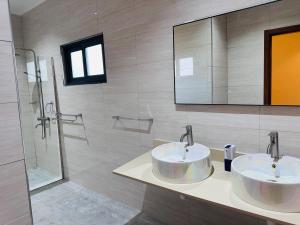 a bathroom with two sinks and a shower at Sren Self Catering - One Bedroom II in Anse Royale