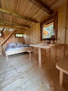 a bedroom with a bed in a wooden cabin at Tree house - Ethno holistic village Apače in Apače