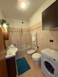 a bathroom with a toilet sink and a washing machine at Skyline 15 Milano - Panoramic Apartment and Free Parking in Milan