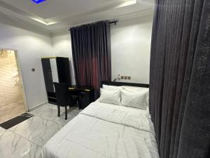 アブジャにあるLa Paz Palacio Homes & Apartments, Airport Road Lugbeのベッドと机が置かれた寝室 +11枚の写真