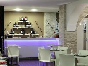 a restaurant with a purple bar with white chairs at Cristal Hotel Palermo in Palermo