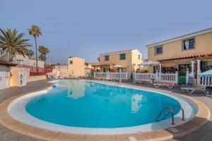 Una gran piscina azul en un complejo turístico. en Bungalow Parrales 2, en Maspalomas