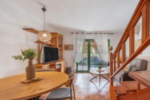 Una sala de estar con una mesa y un comedor. en Bungalow Parrales 2, en Maspalomas