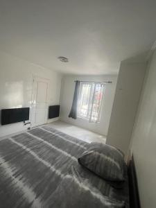 a white bedroom with a bed and a window at 2 bedroom Apartment very close to Paris in Bobigny +1 photo
